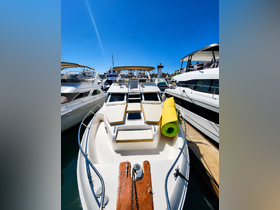 A clear view of a yacht docked at the marina, showcasing its sleek design and inviting seating area, perfect for leisurely outings on the water.