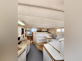 Interior view of a spacious boat cabin featuring comfortable seating and a well-equipped lounge area, perfect for relaxation while cruising.