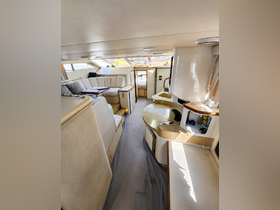Interior view of a spacious boat cabin featuring comfortable seating and a well-equipped helm, perfect for relaxing or navigating on the water.