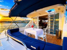 A beautifully designed lounge area on a yacht, featuring comfortable seating and a dining table, perfect for enjoying sunset views while cruising.