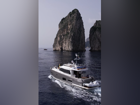 A luxurious yacht navigates the stunning waters near Capri, showcasing breathtaking rock formations and a perfect day on the water.