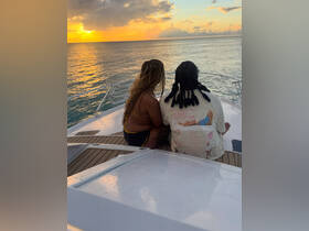 A couple enjoys a romantic sunset view from the deck of a yacht, creating the perfect atmosphere for special moments on the water.