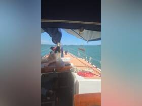 A guest relaxes on the deck of a sailboat, enjoying the sunny ocean views — a perfect moment for unwinding while sailing.