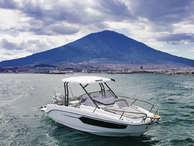 A sleek boat navigates the waters with a stunning mountain backdrop, showcasing the perfect setting for a day on the water.