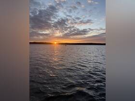 A stunning sunset over tranquil waters, with reflections shimmering on the surface — a perfect scene for evening boat trips or peaceful moments by the shore.