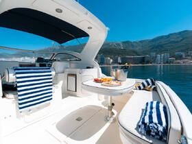 A beautifully arranged table on a boat featuring a selection of fruits and drinks, perfect for enjoying a relaxing day on the water with friends or family.