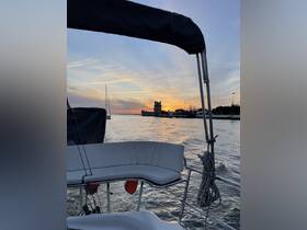 A serene sunset view from a boat, showcasing the tranquil waters and a historic tower in the background, perfect for evening cruises.