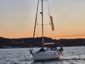 A beautiful sunset view of a sailing yacht named 'Spritz' cruising through calm waters, perfect for evening adventures on the sea.
