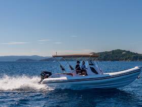 A speedboat glides through the sparkling waters, with two individuals enjoying the ride — perfect for adventure seekers exploring the coastline.