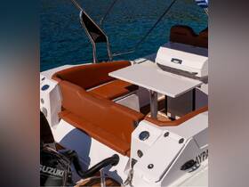 A stylish interior view of a boat's seating area, featuring comfortable brown cushions and a sleek table, perfect for relaxing while enjoying the water.