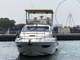 A sleek yacht is docked, showcasing its elegant design against a backdrop of a Ferris wheel, perfect for luxury outings on the water.