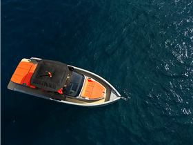 Aerial view of a sleek speedboat with vibrant orange seating, gliding over deep blue waters — perfect for thrilling adventures on the open sea.