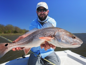 An angler proudly displays a freshly caught fish while enjoying a day of fishing on the water — a perfect moment for fishing enthusiasts.