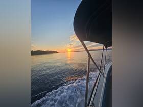 A serene sunset view from the side of a boat, showcasing the tranquil waters and the silhouette of the shoreline — perfect for evening cruises.