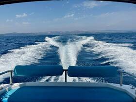 A stunning view from the back of a boat, showcasing the wake as it cuts through the vibrant blue waters, perfect for a day of adventure on the sea.