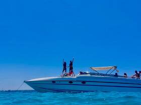 A lively group celebrates on the bow of a speedboat, enjoying the summer sun and clear waters — perfect for unforgettable boating adventures.