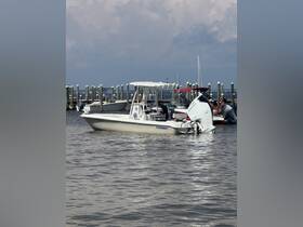 A sleek center console boat docked at the marina, showcasing its design against a backdrop of calm waters and cloudy skies.