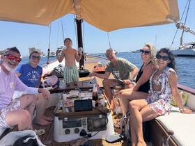 A joyful group enjoys a sunny day on a boat, sharing laughter and good food — perfect for family gatherings or celebrations on the water.