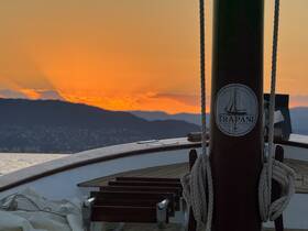 A stunning sunset view from the deck of a boat named 'Trapani,' showcasing the vessel's elegant hull against a vibrant sky — perfect for romantic evening cruises.