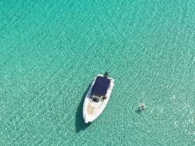 An aerial view of a boat anchored in crystal-clear waters, with a person swimming nearby, showcasing the perfect day for aquatic adventures.