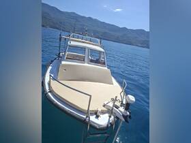 A clear view of a fishing boat with a spacious front deck, set against a backdrop of serene blue waters and lush green mountains, ideal for fishing trips or leisurely outings.
