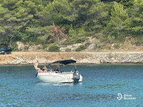 A lively group enjoys a summer day on the water, with one person preparing to jump off the boat, capturing the essence of fun and adventure.