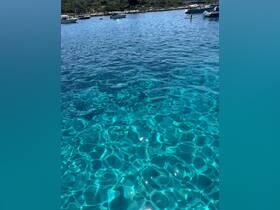 A picturesque view of crystal-clear waters with a paddleboarder enjoying the serene surroundings — a perfect snapshot of a relaxing day on the water.