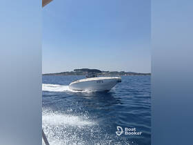A sleek speedboat navigates through clear waters, showcasing its design and performance under the bright sun.