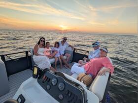A joyful family enjoys a sunset cruise on a boat, creating cherished memories together as they relax and take in the beautiful views.