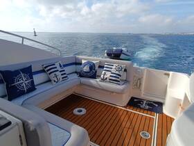 A cozy interior view of a boat's seating area, featuring nautical-themed cushions and a polished wooden floor, perfect for relaxing while cruising on the water.