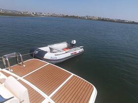 A sleek speedboat is docked on calm waters, showcasing its design against a scenic backdrop of the city skyline.