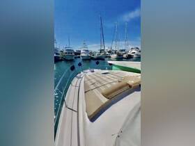 A stunning view of a yacht docked at a marina, showcasing the boat's sleek design against a backdrop of other vessels and clear blue skies.
