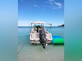 A rear view of a boat anchored in clear waters, showcasing its sleek design and tranquil surroundings — perfect for a day of fishing or leisure on the water.