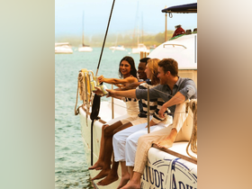 A joyful group of friends enjoying drinks on the side of a yacht, capturing the essence of celebration and camaraderie on the water.