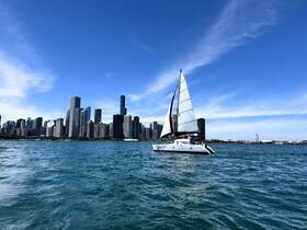 A sleek sailboat glides through the vibrant waters with a stunning city skyline in the background, showcasing the perfect blend of urban and nautical beauty.