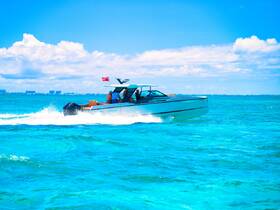 A sleek speedboat glides through vibrant turquoise waters, showcasing an exhilarating day on the ocean.