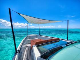 A stunning view from the bow of a boat, showcasing the vibrant turquoise waters and a clear blue sky, perfect for a day of relaxation on the water.