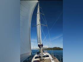A stunning view of a sailboat underway, showcasing its majestic sails against a clear blue sky and picturesque landscape — perfect for sailing enthusiasts.