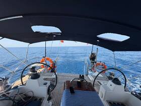 A view of the helm area inside a sailboat, showcasing the steering wheel and control console, perfect for navigating the open waters.