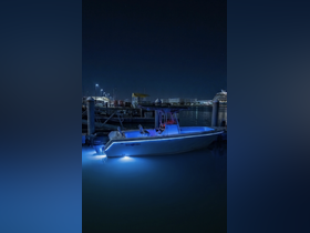 A sleek speedboat illuminated by blue lights, docked at night, showcasing its stylish design and ambiance — perfect for evening cruises.