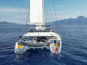 A stunning aerial view of a catamaran sailing through clear waters, with guests enjoying the sun and relaxing on the deck — perfect for a memorable day on the water.
