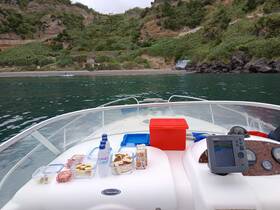 A selection of snacks and drinks laid out on the deck of a boat, perfect for a day of relaxation on the water.