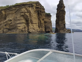 A stunning view of dramatic coastal cliffs rising from the water, captured from a boat — perfect for showcasing the natural beauty of the landscape.