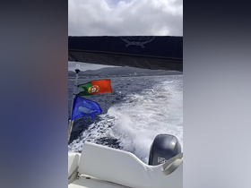 A view from the back of a boat in motion, showcasing the waves and flags fluttering in the wind, perfect for capturing the essence of a boating adventure.