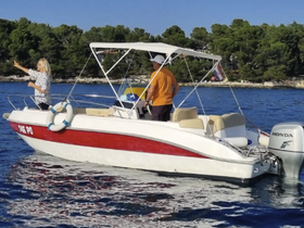 A couple enjoys a sunny day on a boat, with one person capturing the moment while the other navigates — perfect for memorable outings on the water.
