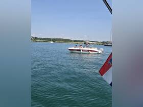 A speedboat navigates through calm waters, showcasing a fun day on the water with friends. Perfect for summer adventures and exploring coastal destinations.