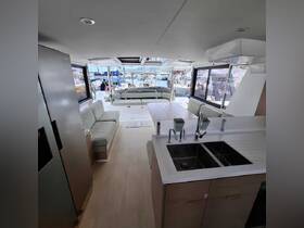 A spacious and modern interior of a boat featuring comfortable seating and a well-equipped kitchen area, perfect for relaxing and entertaining while on the water.