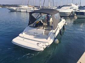 A sleek speedboat named 'Spirit' docked in a serene marina, showcasing its elegant design against a backdrop of other vessels.