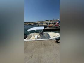 A center console boat docked at the marina, showcasing its sleek design against a clear blue sky — perfect for fishing or day trips on the water.