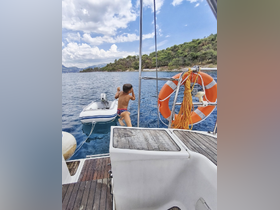 A child prepares to jump from the boat into the clear blue water, capturing the excitement of a fun day on the water.